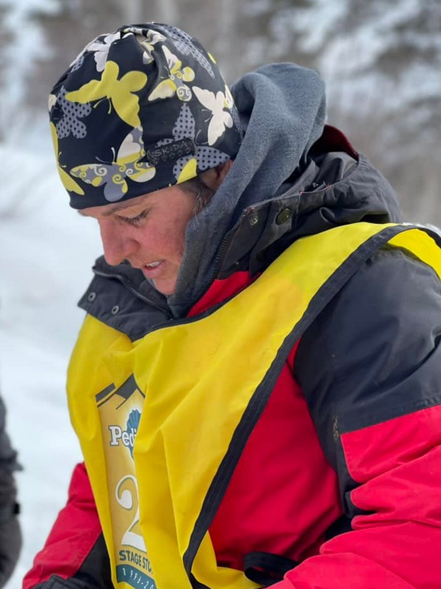 Anny Malo mit Mütze und gelber Startweste, den Blick nach unten gerichtet