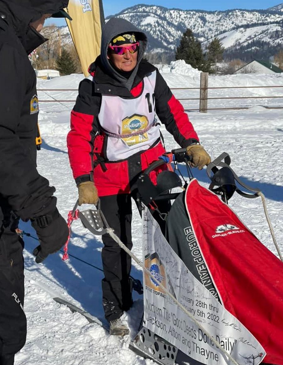 Anny Malo mit Startnummer neben ihrem Schlitten im Zielgelände